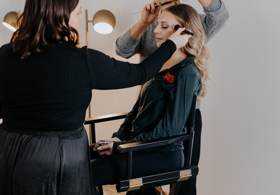 Bridal party preparing the bride with hair and makeup before a wedding ceremony.